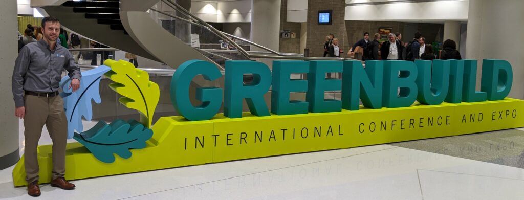 A green sign sitting on top of a yellow stand.